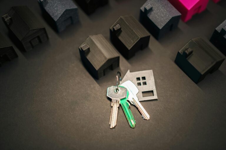 black miniature houses and house keys in the middle