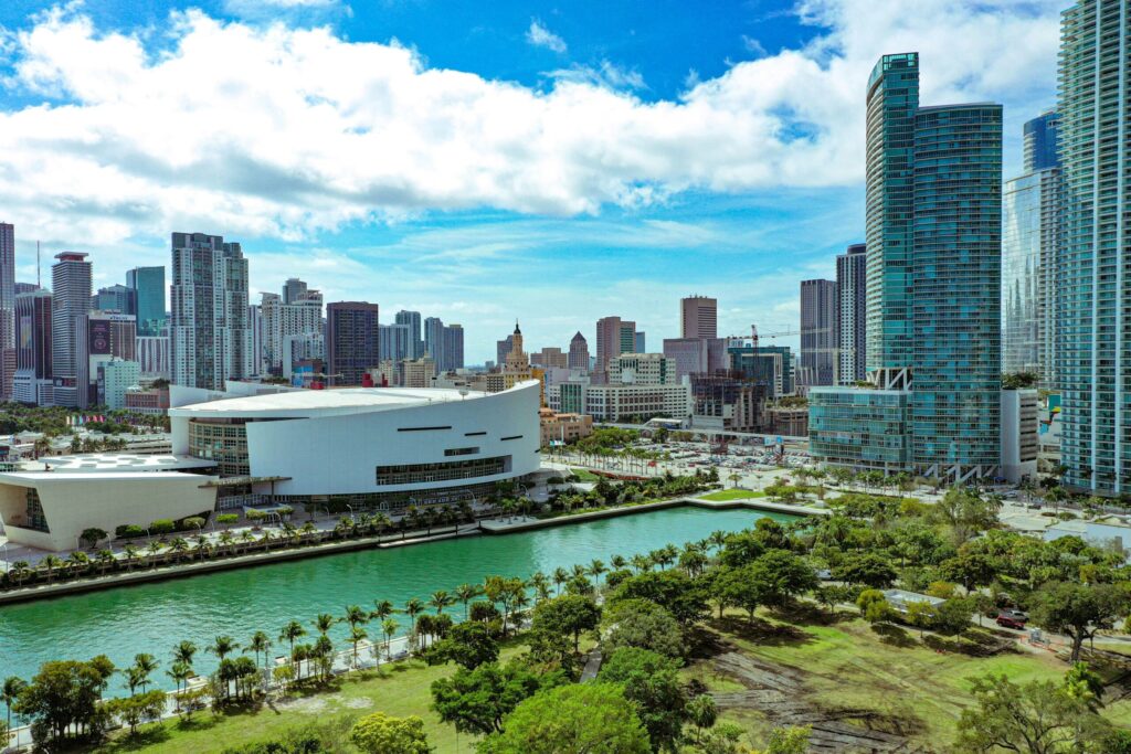 High rise buildings near green trees under a blue sky during daytime