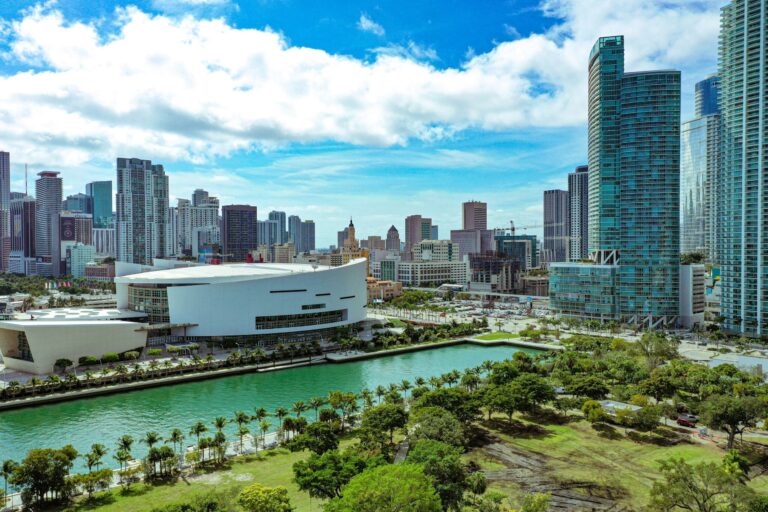 High rise buildings near green trees under a blue sky during daytime