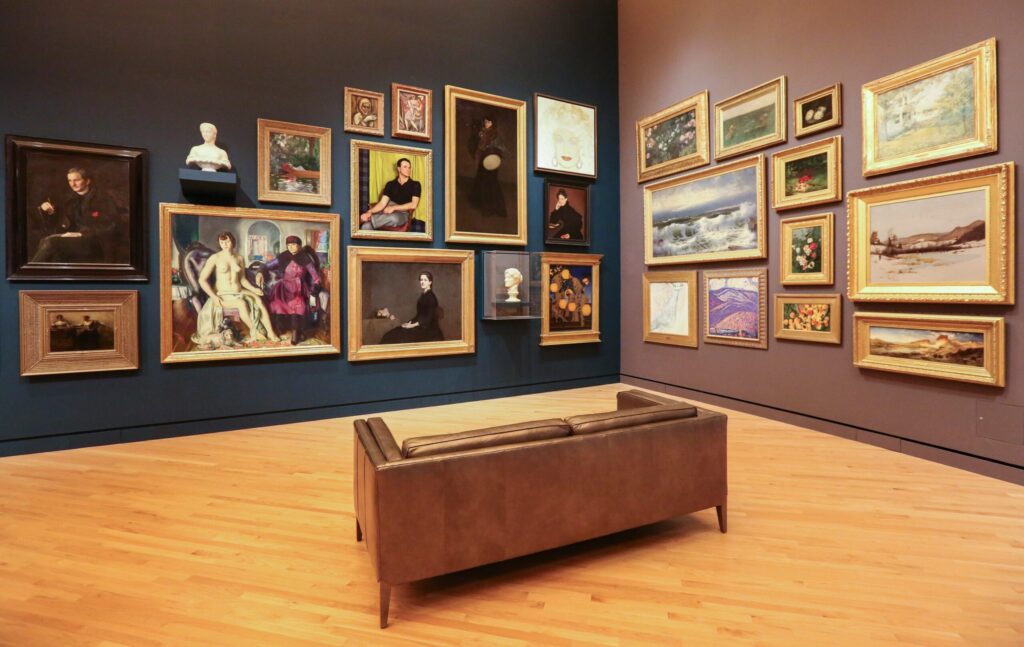 brown loveseat surrounded by paintings